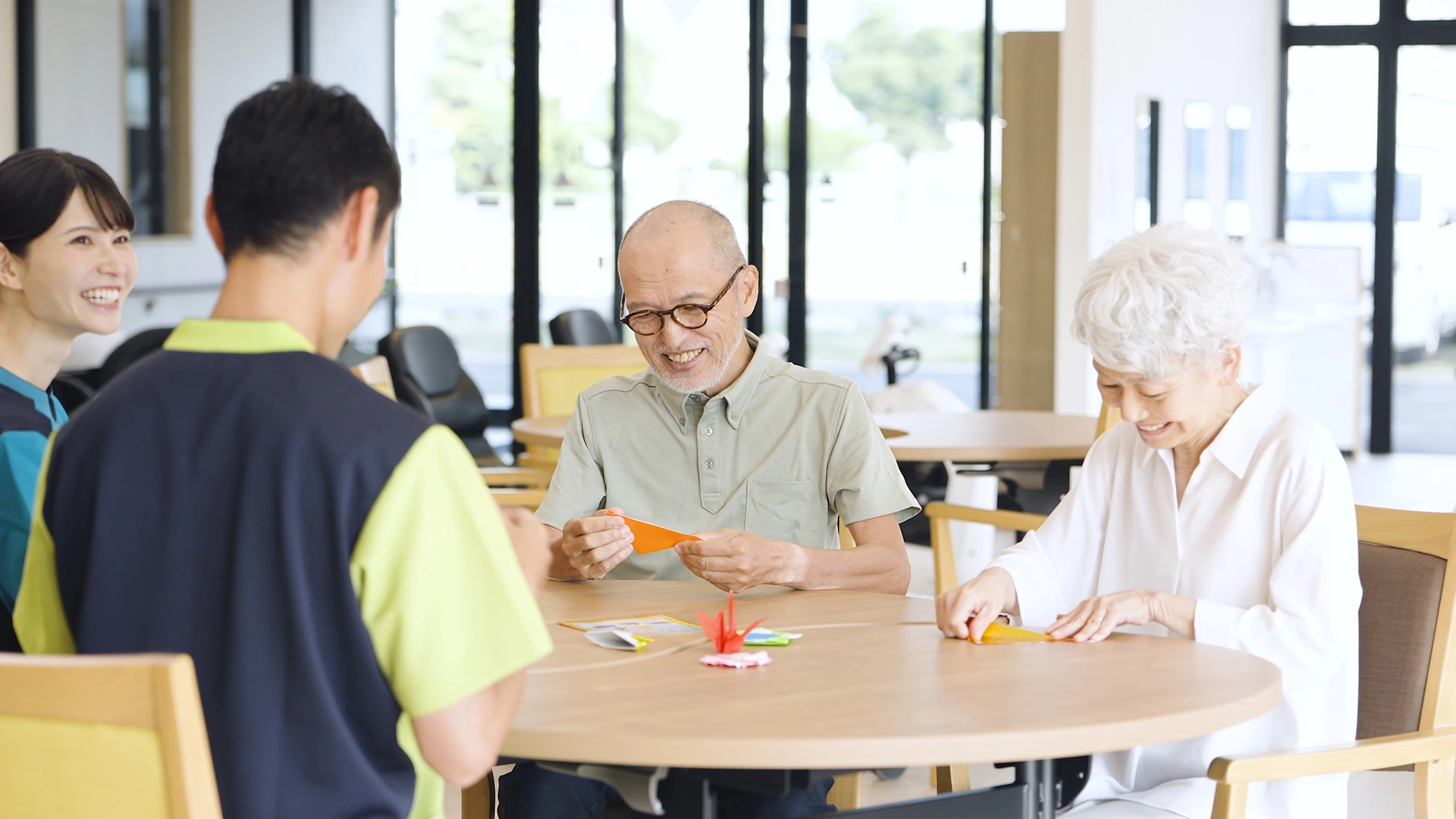 People of different ages making origami together around a table